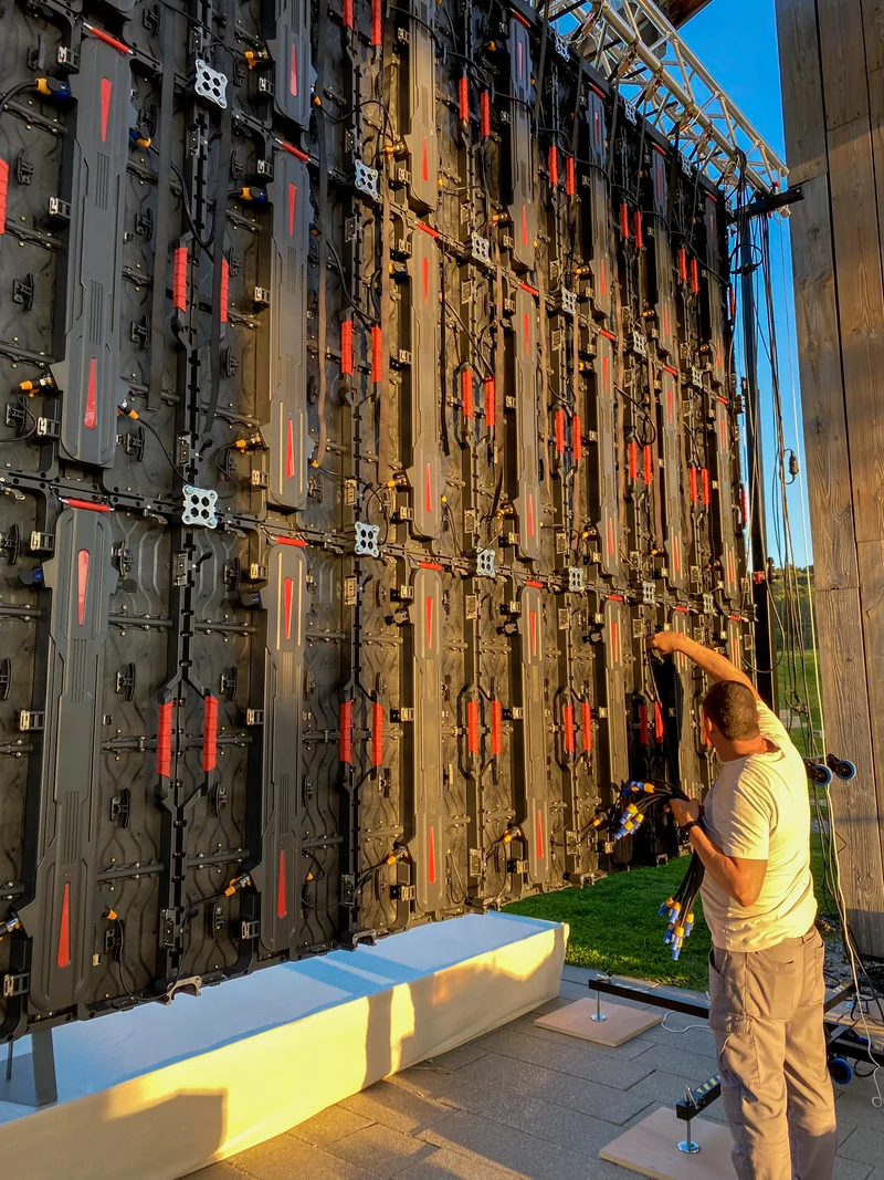 Technician connecting panels behind an LED wall